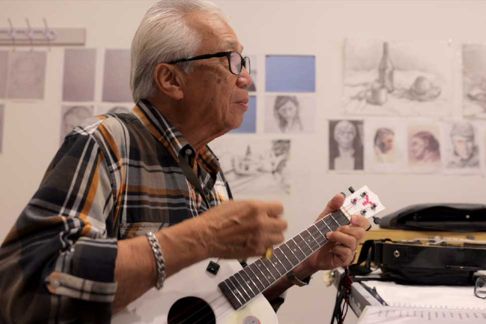 Older man playing tenor guitar