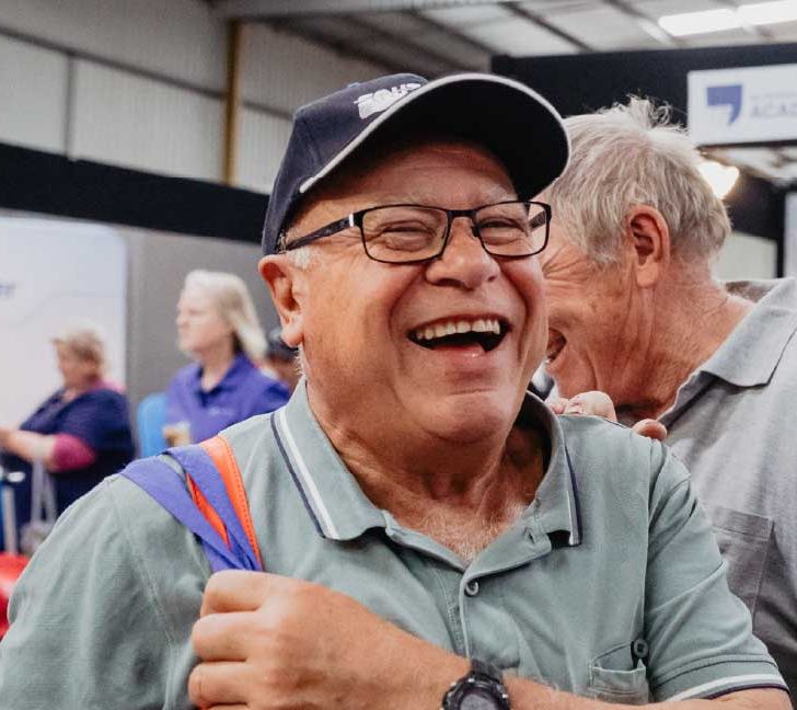Older man wearing a hat attending an aged care event
