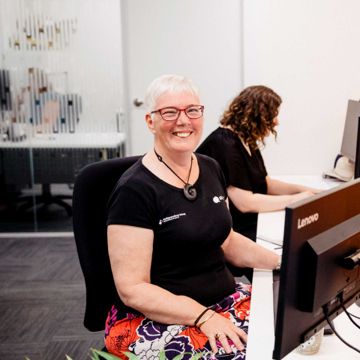 iLA staff member smiling while working at her desk