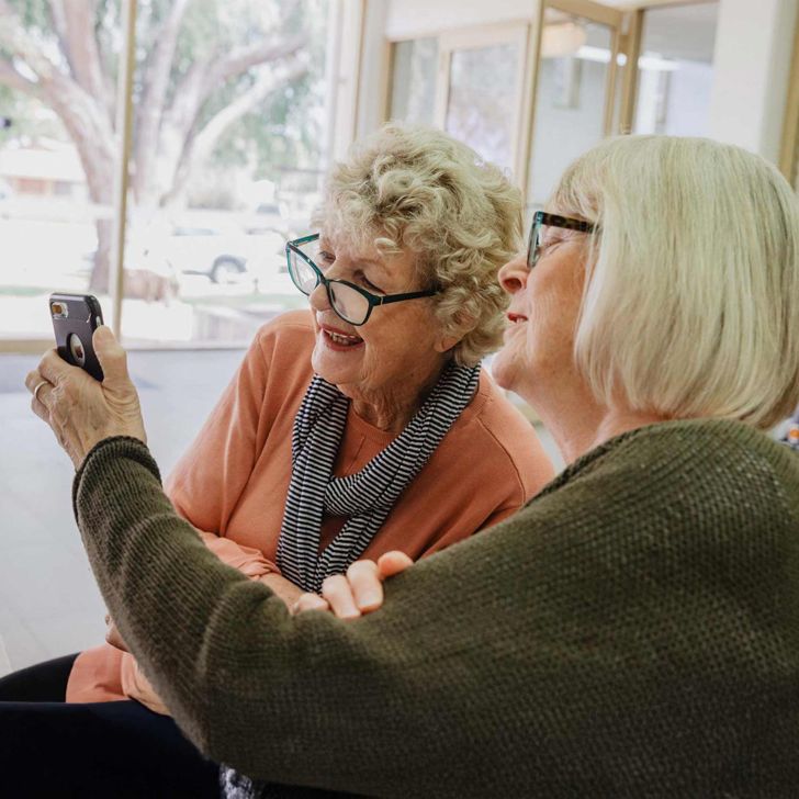 two older women looking at a smartphone