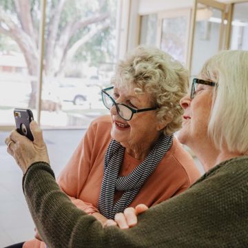 one woman showing another woman content on her mobile phone