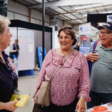 Engagement team member at an expo chatting to visitors about LiveUp