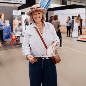 A senior lady at an aged care expo reading our brochure