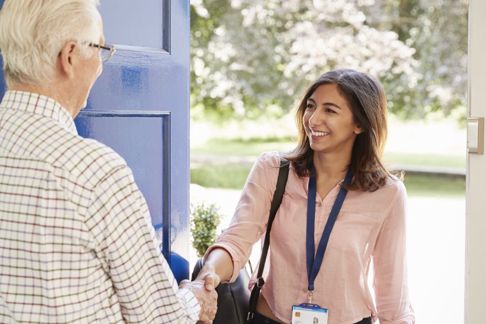 A support worker arriving at a clients home shaking hands at the front door