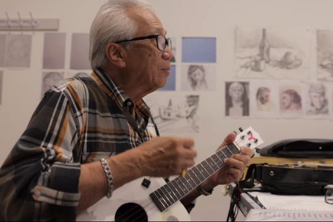 Older man playing tenor guitar