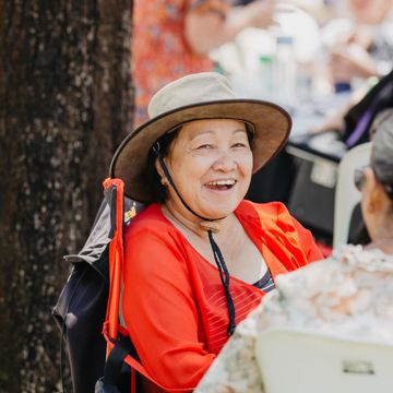 Older lady smiling while sitting in a park