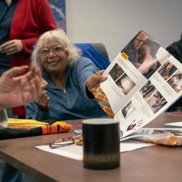 An indigenous lady holding the Mob Guide Toolkit brochure
