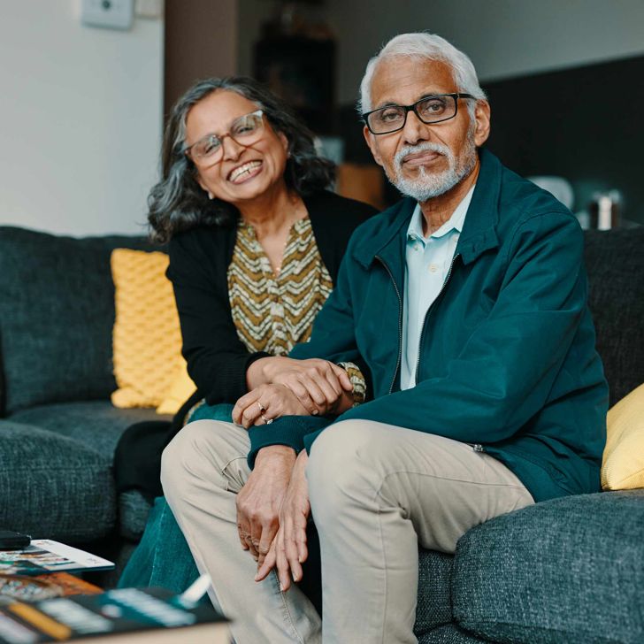 An older couple sat on their sofa at home