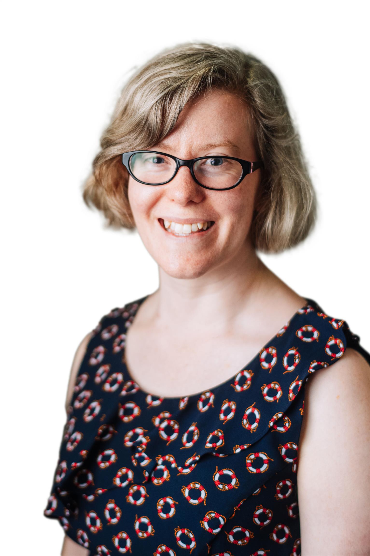 Dr Claire Cook smiling female with blonde hair, wearing a green & white dotted dress