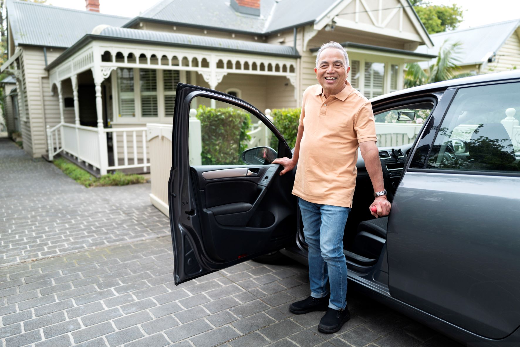 Older man smiles as he gets out of car Older man smiles as he gets out of car