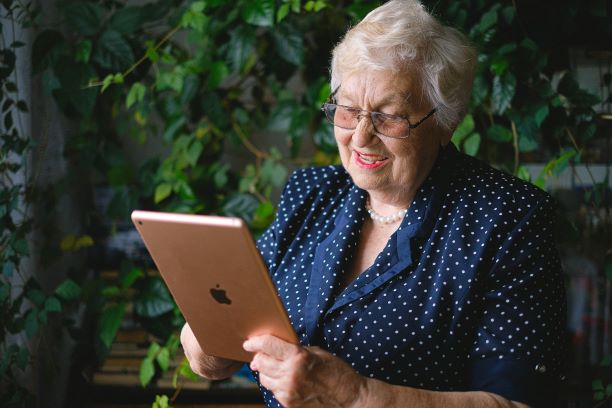 older lady with ipad in the garden
