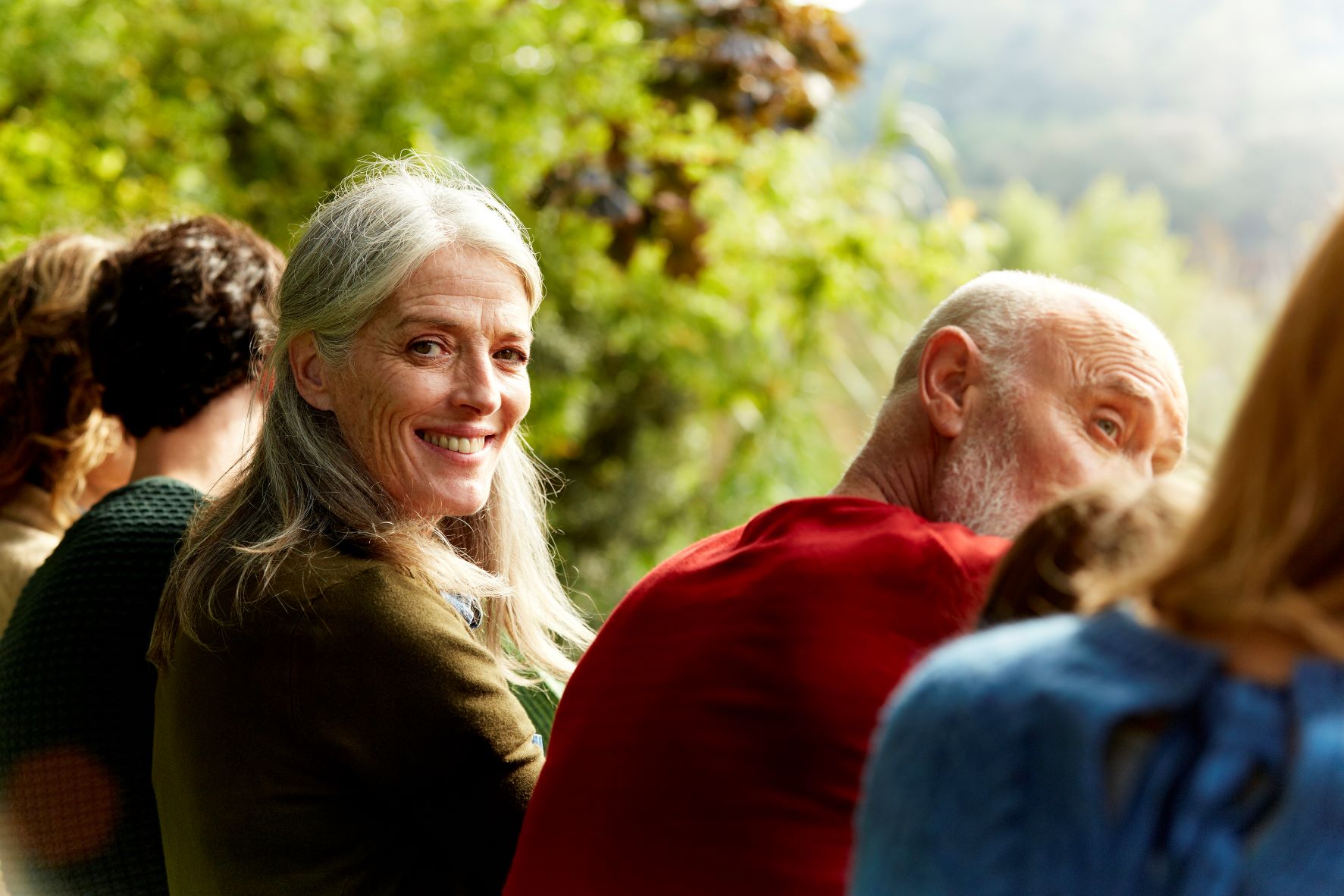 A lady helps an older lady and they both smile.