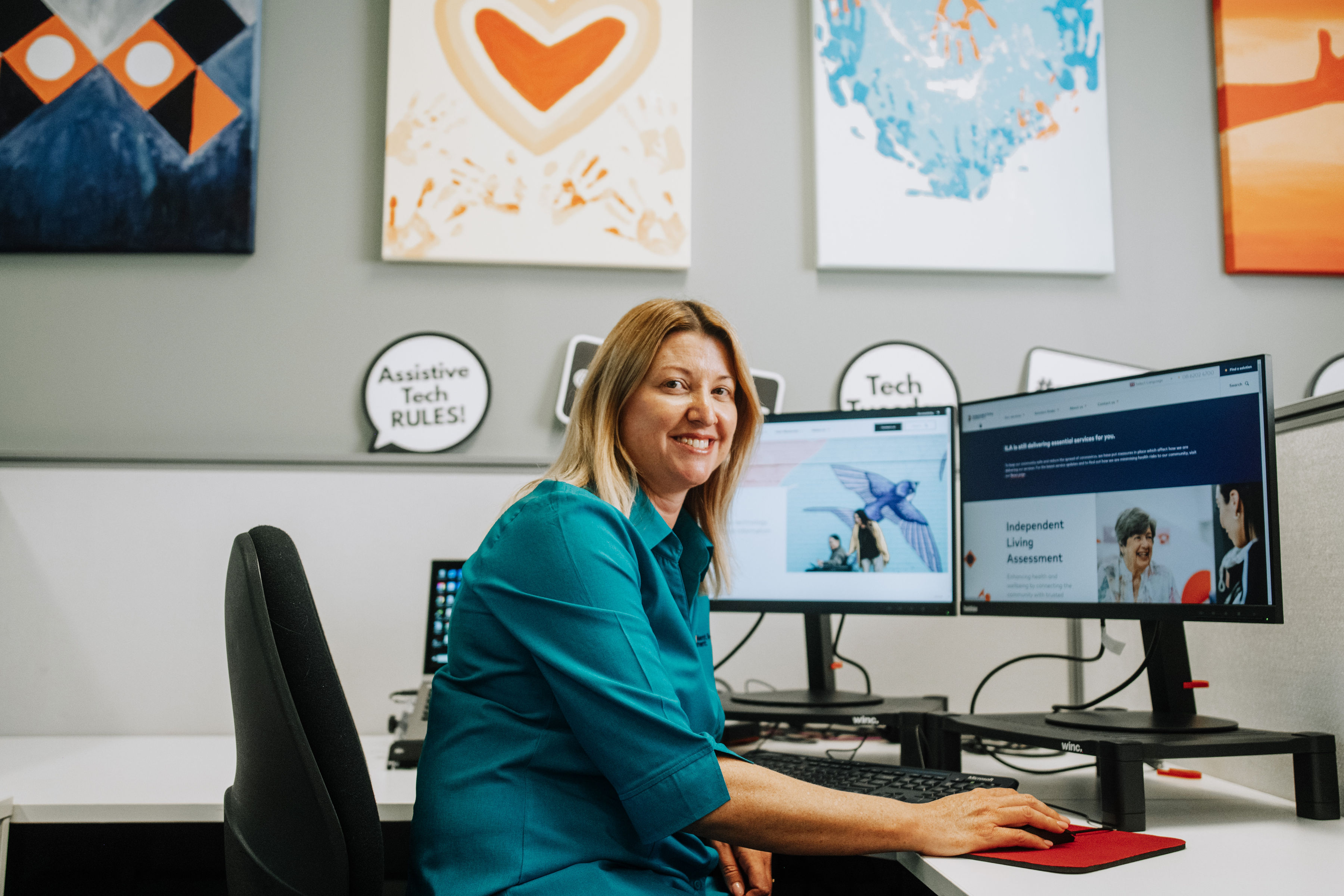 Professional female smiling sitting at workstation using a computer