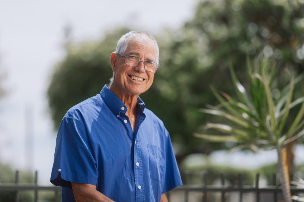 Male_Customer_Community Male in blue shirt and glasses smiling while outside
